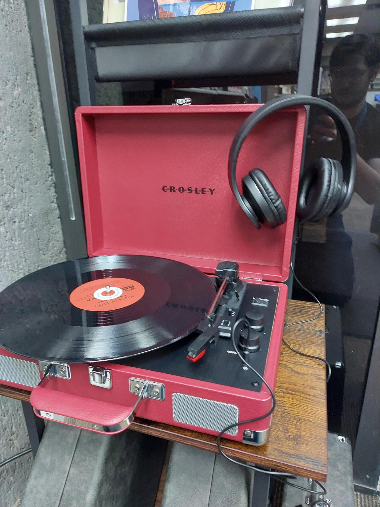 Picture with vinyl record on player with headphones resting on top of the case